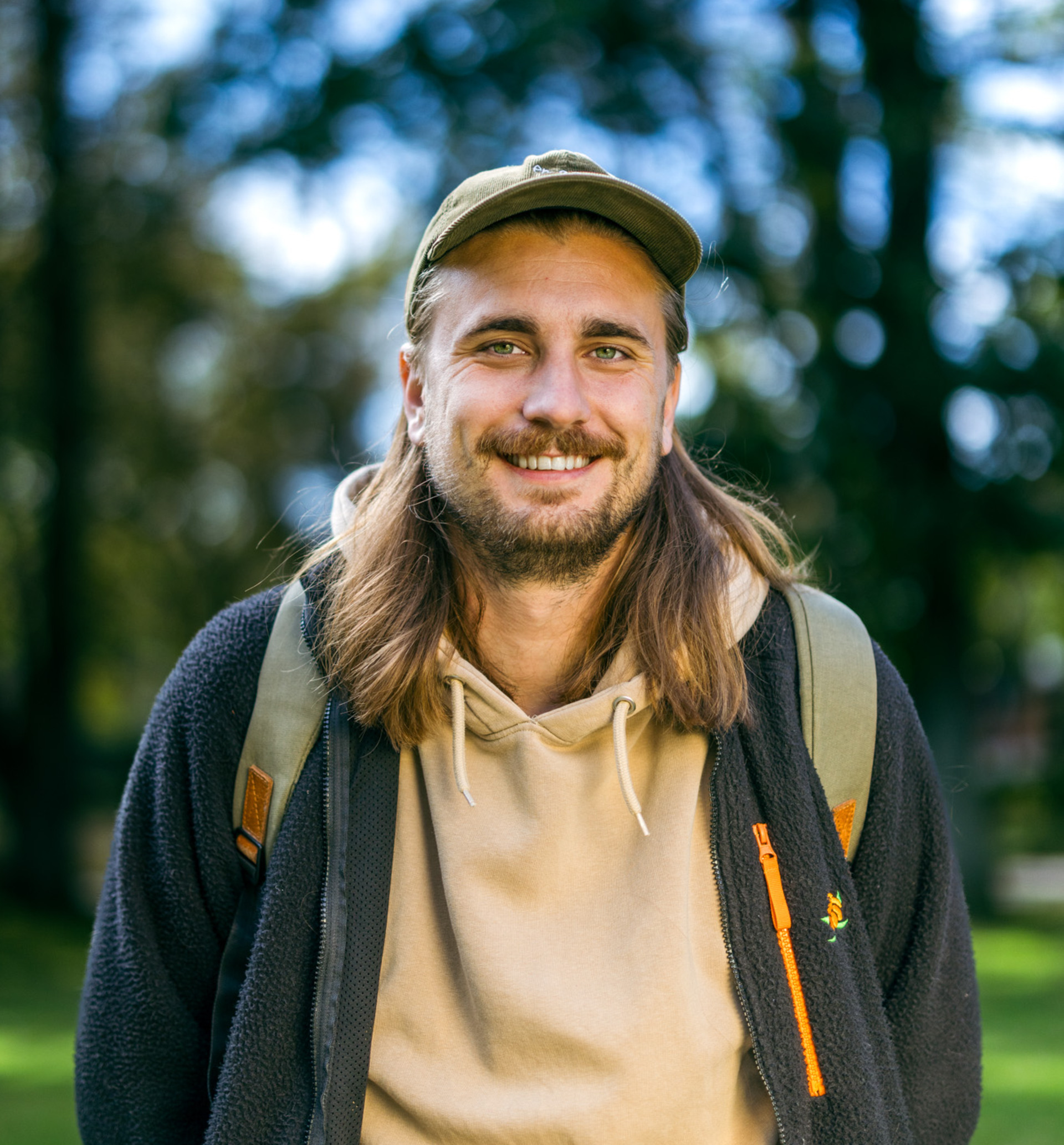 Porträttbild av ung, leende man i en grönskande omgivning i Höganäs